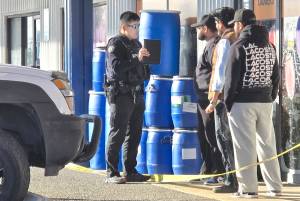 A police officer interviews workers at the scene of a shooting on the Langley Bypass. No injuries were reported. (Dan Ferguson/Black Press Media)