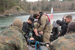 Divers prepare at Whirl Bay underwater demolition range during Exercise Roguish Buoy, where Canadian and visiting army dive teams execute tasks in support of operations, and to provide the recertification necessary to maintain the rigorous standards required for Army Combat Divers. (Christine van Reeuwyk/Goldstream Gazette)
