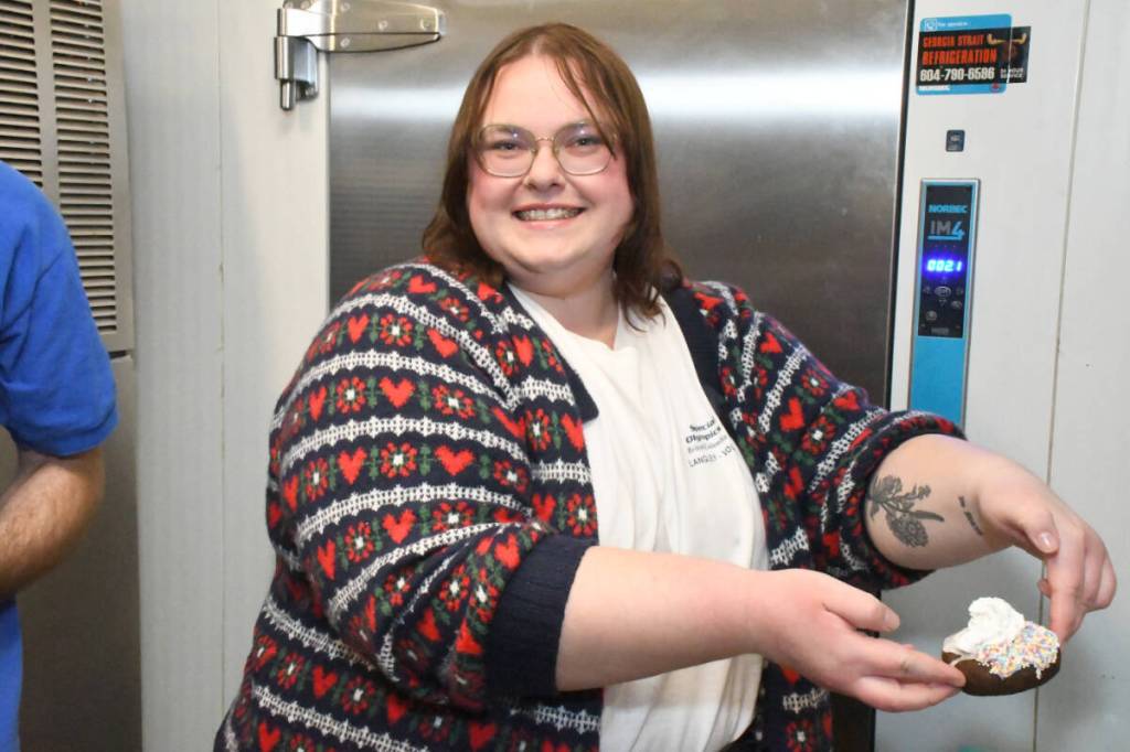 Kayla Brouwer, a volunteer with Special Olympics and a swim coach, took a turn making one of the fundraising donuts at Tim Hortons. (Heather Colpitts/Langley Advance Times)